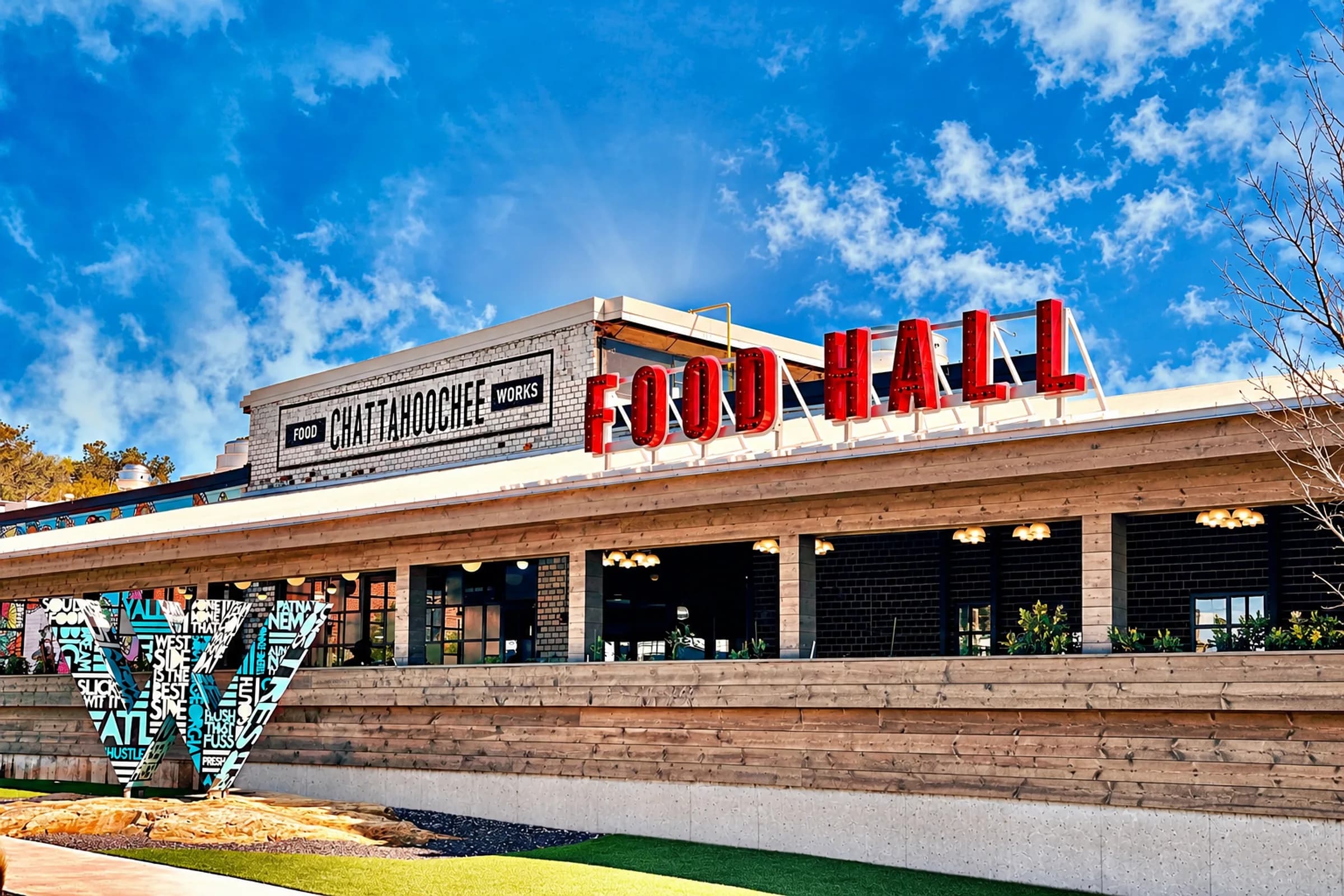 The exterior of Chattahoochee Food Works with its rooftop sign and public art