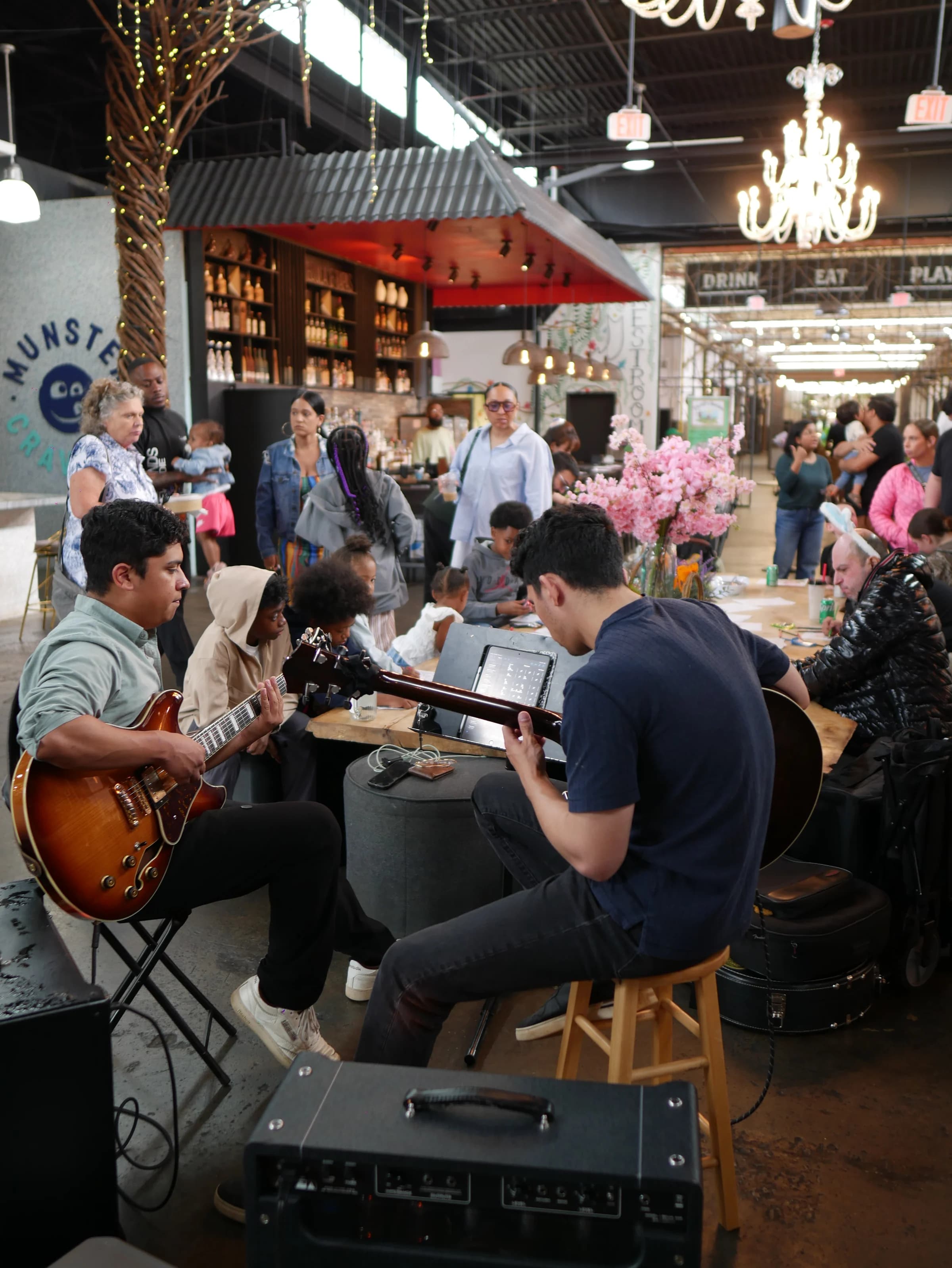 Guests gather around a guitarist playing inside Chattahoochee Food Works